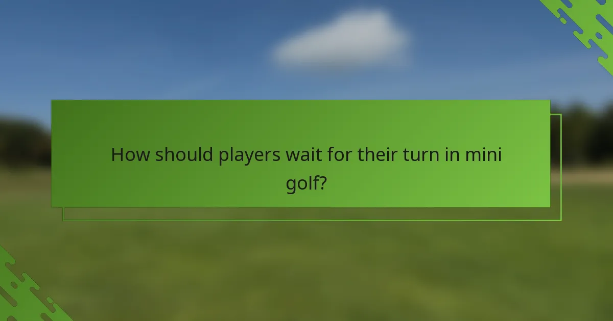 How should players wait for their turn in mini golf?